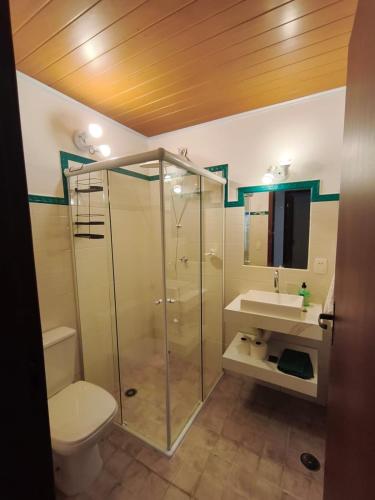 a bathroom with a shower and a toilet and a sink at Quinta do Sahy in São Sebastião