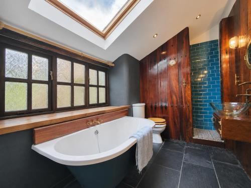 a bathroom with a large tub and a toilet at Ysgol Hill Main House in Rosebush