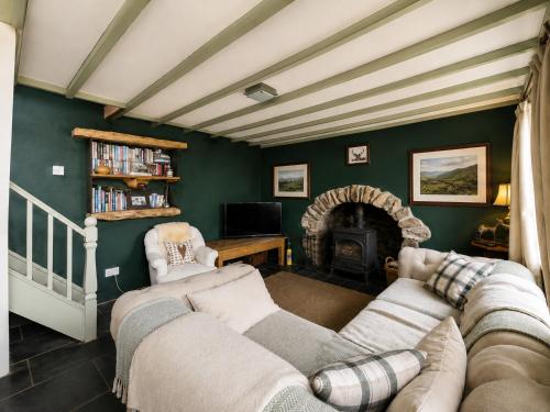 a living room with two couches and a fireplace at Ysgol Hill Main House in Rosebush