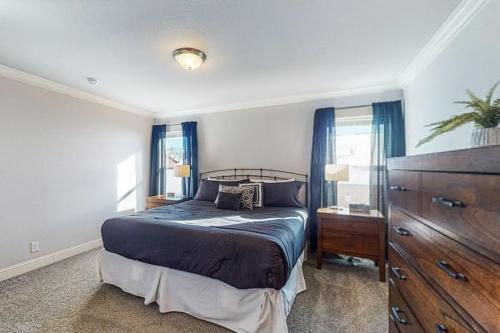 a bedroom with a bed and a dresser and windows at Quail Nest on Quail Drive in Fraser
