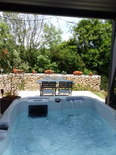 a jacuzzi tub with two chairs and a table at Domaine Chante-Cevennes in Frouzet