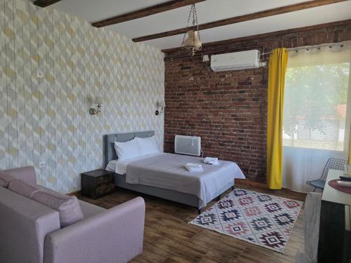 a bedroom with a bed and a brick wall at Conacul Ancuței in Brad