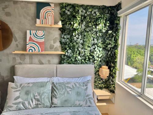 a bedroom with a green wall with a bed and a window at Marina Spatial Condo Unit 16 MountainView Studio in Piapi