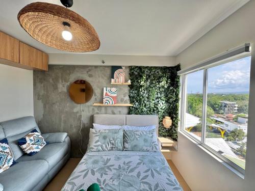 a room with a bed and a couch and a window at Marina Spatial Condo Unit 16 MountainView Studio in Piapi
