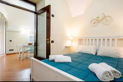 a bedroom with a blue bed with a bike on the wall at Dogana House in Catania
