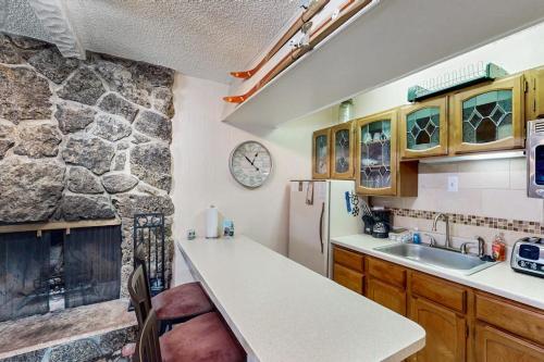 a kitchen with a stone wall and a refrigerator at Hi Country Haus Hideaway in Winter Park