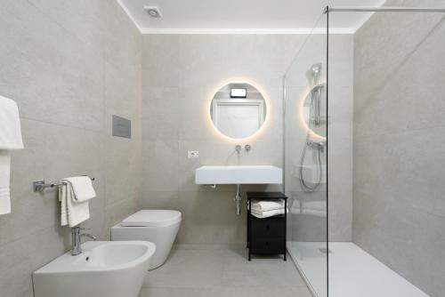 a bathroom with a sink and a toilet and a mirror at Sea View Hotel Fronte Mare in San Vito lo Capo