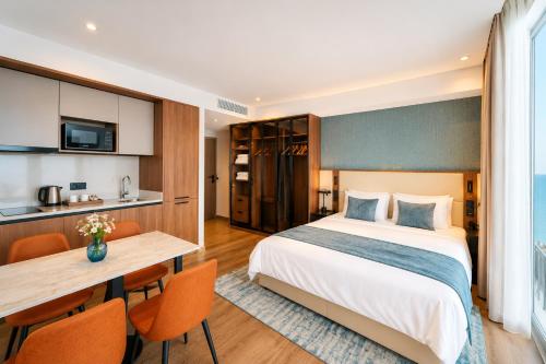 a hotel room with a bed and a table at Signature Residence Sea View Suites in Marriott Privilege in Batumi