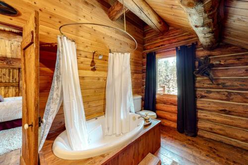 a bathroom with a tub in a log cabin at Durango Dreams in Durango