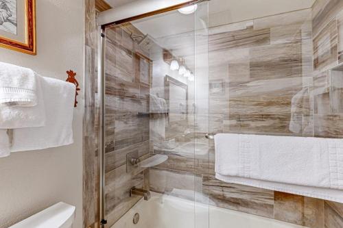a bathroom with a tub and a glass shower at Torian Plum Plaza 302 in Steamboat Springs