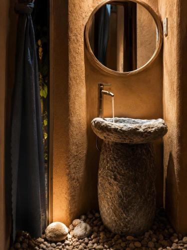 a bathroom with a stone sink and a mirror at Tom Home Retreat in Mỹ Lại (1)