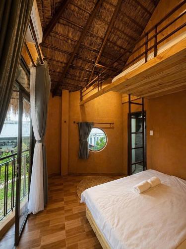 a bedroom with a bed and a large window at Tom Home Retreat in Mỹ Lại (1)