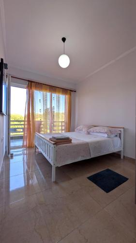 a bedroom with a bed and a large window at Sophi's Dream Apartment in Lalzit Bay