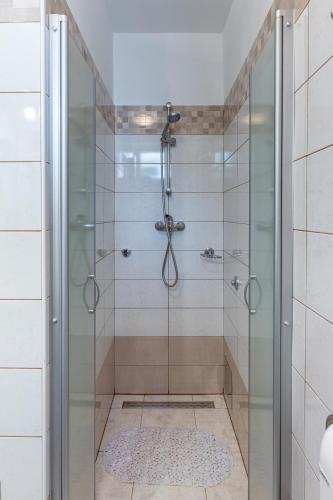 a bathroom with a shower with a glass door at Apartmani Vitković II Cres in Cres
