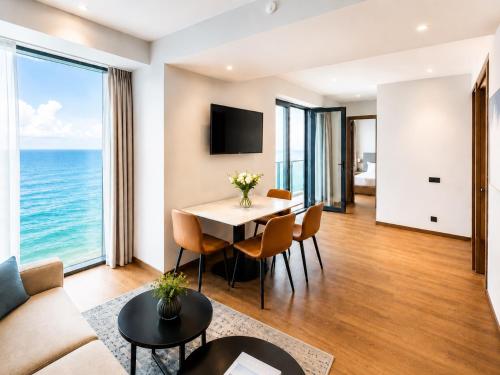 a living room with a table and chairs and the ocean at Signature Residence Sea View Suites in Marriott Privilege in Batumi