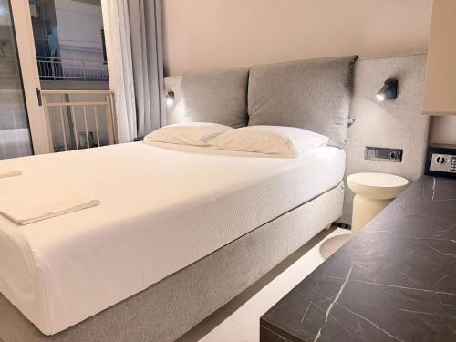 a large white bed in a room with a window at LaK Private Pool Suites in Potos,Thassos in Potos
