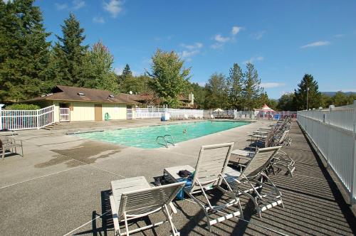 a row of lawn chairs next to a swimming pool at Mount Vernon Camping Resort Studio Cabin 4 in Bow