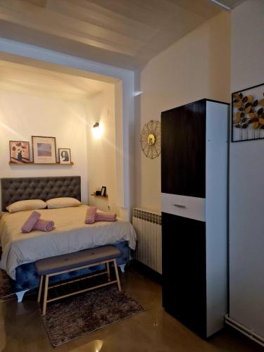 a bedroom with a bed and a large refrigerator at Studio apartman Picok Đurđevac in Ðurđevac