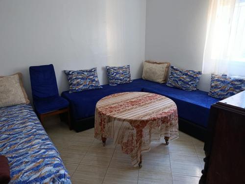 Un sofá azul con una mesa en una habitación. en Ouadlaw, en Oued Laou