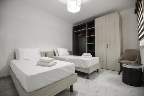 a bedroom with two beds and a chair at B6 Dahlet Ta Cenc in Sannat