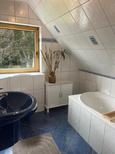 a bathroom with a black tub and a sink at Ferienwohnung Blumenthal bei Kiel in Blumenthal