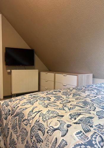 a bedroom with a bed with a blue and white blanket at Ferienwohnung Blumenthal bei Kiel in Blumenthal