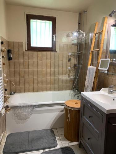 a bathroom with a bath tub and a sink at Maison Vexin in Boury-en-Vexin