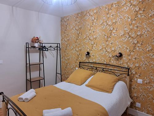 a bedroom with a bed with a floral wallpaper at Gîte Lebasladin in Lison