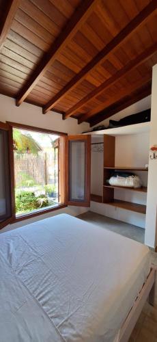 a large bedroom with a large bed with a window at Quinta do Sahy in São Sebastião