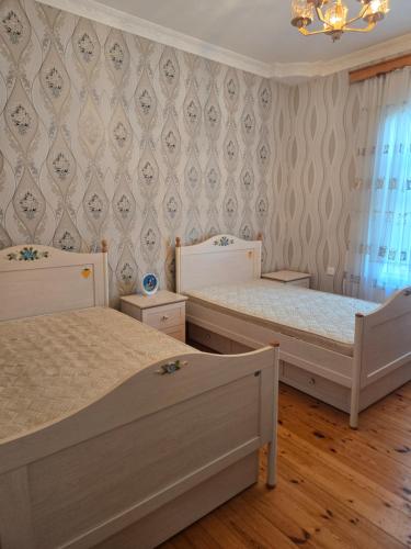 a bedroom with two beds and a wall at Bilgah Garden Villa in Bilgah