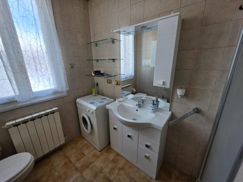 a bathroom with a sink and a washing machine at Appartamento Pullino in Marina di Ravenna