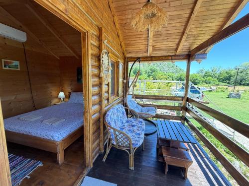 a room with a bed and two chairs on a porch at Camp Sunny Hills in Virpazar