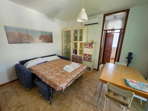 a bedroom with a bed and a table in it at Appartamento Pullino in Marina di Ravenna