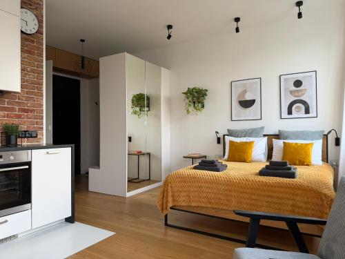 a bedroom with a bed with yellow pillows at Studio Olesińska in Warsaw