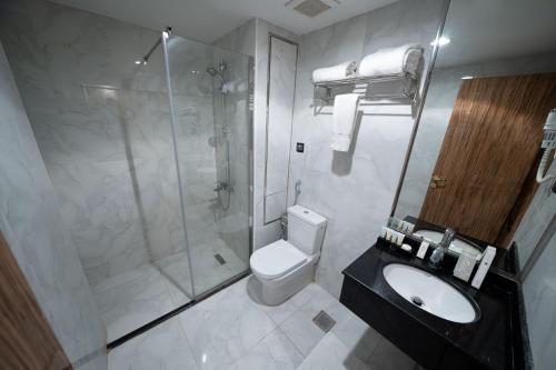 a bathroom with a shower and a toilet and a sink at Lamar Ajyad First Hotel Tower B in Mecca