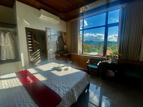 a bedroom with a bed and a large window at Tam Coc Mountain View Homestay in Ninh Binh
