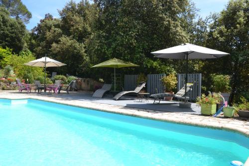 a swimming pool with tables and umbrellas and chairs at Appartement T2 in Montauroux