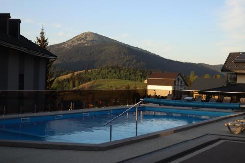 a large swimming pool with a mountain in the background at Князів Двір in Bukovel