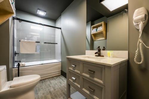 a bathroom with a toilet sink and a shower at La Suite Hotel in Shawinigan