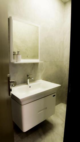 a bathroom with a white sink and a mirror at Greenland HomeINN in Kigali