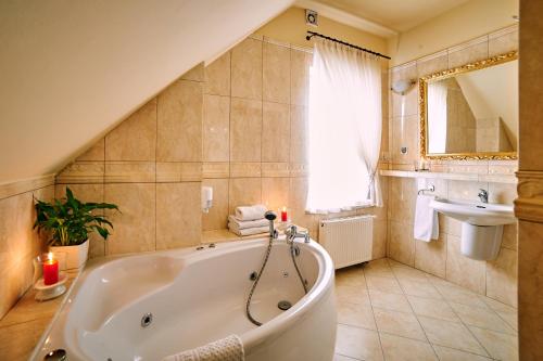 y baño con bañera y lavamanos. en Villa Royal, en Ostrów Wielkopolski