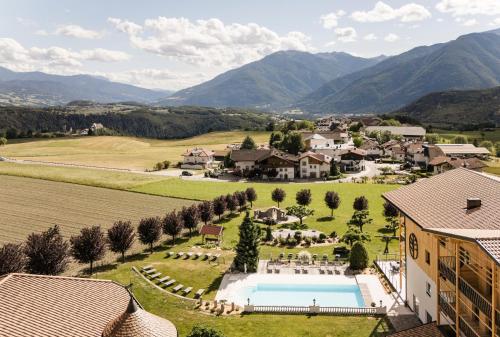 an aerial view of a resort with a pool and mountains at Hotel Nussbaumerhof *** in Rodengo