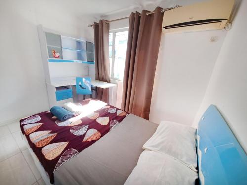 a small bedroom with a bed and a window at Cozy South in Mahébourg