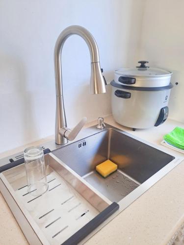 a kitchen sink with a sponge and a sink at Cozy South in Mahébourg