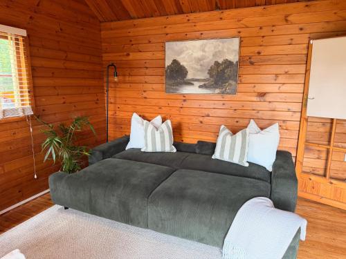 a living room with a black couch with white pillows at Swan cove - Lakeside Caravan Park in Denver