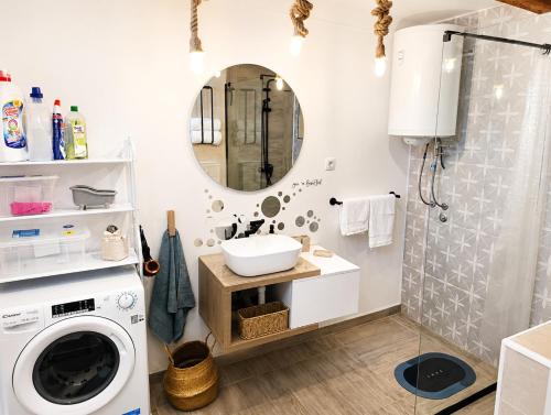 a bathroom with a washing machine and a sink at Nexus Apartman in Apatin