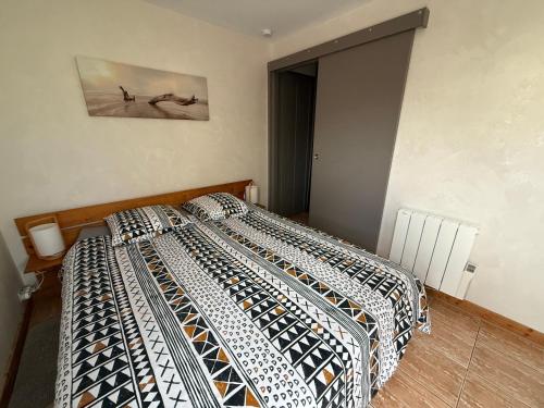 a bedroom with a bed and a painting on the wall at Suite à 800m de la plage in Saint-Lunaire