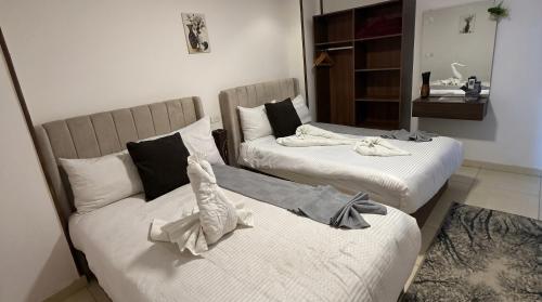 two beds in a room with a couch at King Badr Pyramids Inn in Cairo