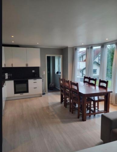 a kitchen and dining room with a table and chairs at Sentral leilegheit i Ørsta in Ørsta