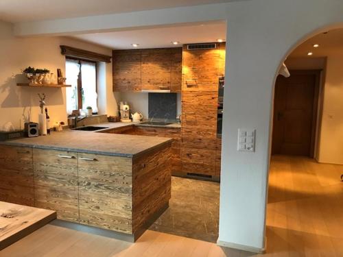 a large kitchen with a large island in a room at Genuss in den Bergen! in Klosters Serneus